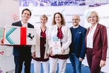 Prof. Jan Steffen Jürgensen, Vorstand des Klinikums Stuttgart, gratuliert Stationsleiterin Ines Filster und ihrer Stellvertreterin Dorothea Laug. Oliver Hommel, Pflegedirektor im Klinikum Stuttgart und Christine Kohls (ehemalige Patientin) schließen sich den Glückwünschen an (Bild: Klinikum Stuttgart/ Tobias Grosser).