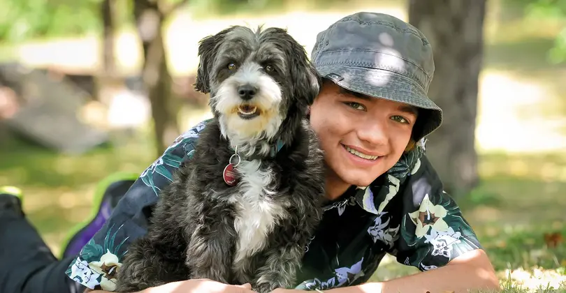 Jannis liegt mit seinem Hund auf der Wieso