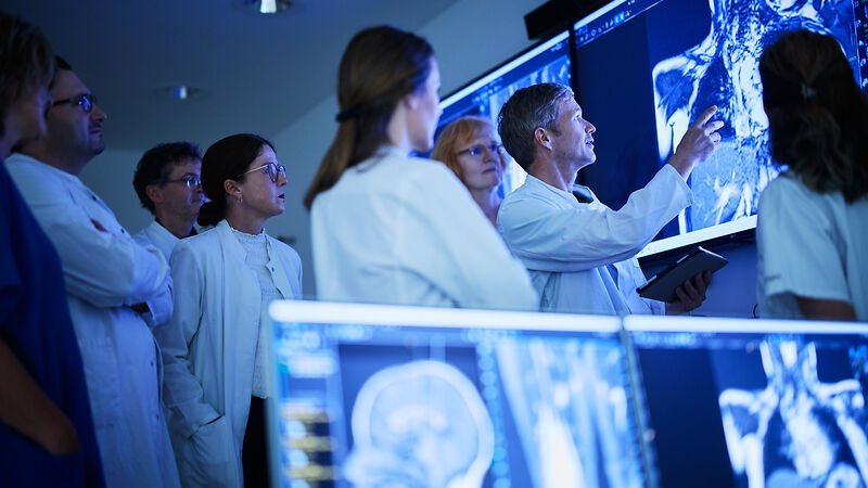 Interdisziplinäre Fallkonferenz mehrerer Ärzte vor Röntgenaufnahme